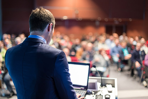 Public speaker giving talk at business event.